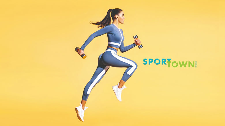Девушка в спортивном костюме бежит с гантелями в руках на желтом фоне с надписью SportTown