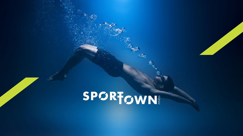 Спортсмен под водой на фоне надписи SportTown Fitness