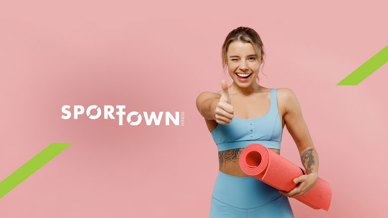 Спортивная девушка с ковриком для йоги стоит на фоне надписи SportTown!