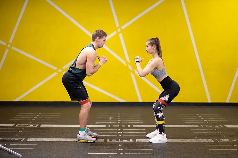 Спортивные парень с девушкой тренируются в фитнес-клубе Come On Gym